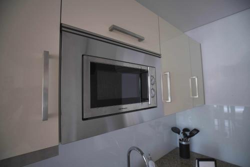 a flat screen tv on a wall in a kitchen at Camoes StudioGeral in Bragança