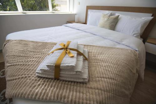 a bed with towels and a bow on it at Camoes StudioGeral in Bragança