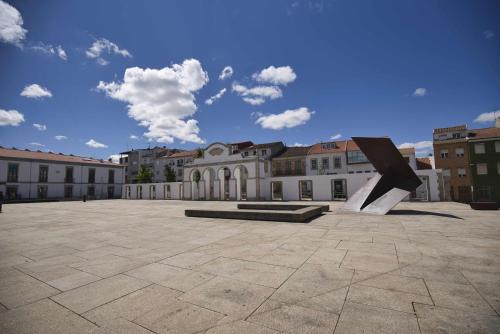 a sculpture in a courtyard in front of a building at Camoes StudioGeral in Bragança