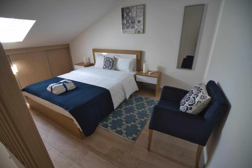 a bedroom with a bed and a blue chair at Camoes StudioGeral in Bragança