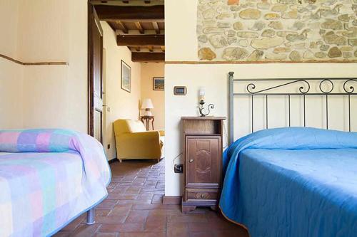 1 Schlafzimmer mit 2 Betten und einem Stuhl in der Unterkunft Appartamenti con cucina nelle colline toscane in Anghiari