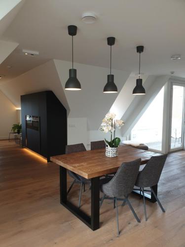 a dining room with a wooden table and chairs at Penthouse Windkracht 10 aan het strand van Cadzand in Cadzand