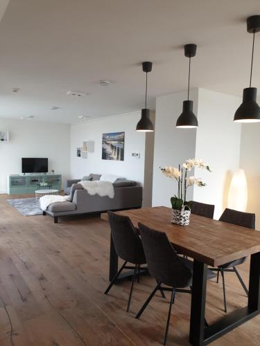 ein Wohnzimmer mit einem Tisch und einem Sofa in der Unterkunft Penthouse Windkracht 10 aan het strand van Cadzand in Cadzand