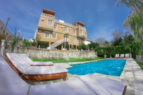 a house with a swimming pool in front of a house at Hotel Casablanca in Mina Clavero