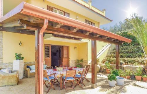 a patio with a table and chairs under a pergola at Villa Summer in Trappeto