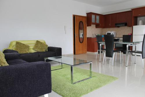 a living room with a couch and a table and chairs at Galatia's Court in Paphos City