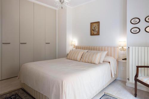 ペーザロにあるCasa del Teatro appartamento con splendida terrazzaの白いベッドルーム(ベッド1台、椅子付)