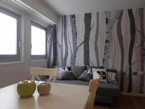 ein Wohnzimmer mit einem Sofa und einem Tisch mit zwei Äpfeln in der Unterkunft Bilocale con cucina a 300 m dalle piste in Passo del Tonale