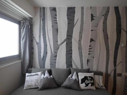 a bedroom with a wall mural of trees and bats at Bilocale con cucina a 300 m dalle piste in Passo del Tonale