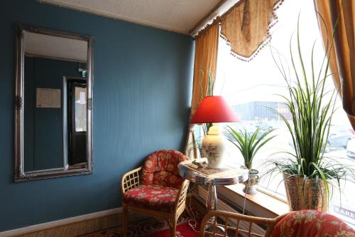a room with a chair and a lamp and a window at Barents Hotell in Kirkenes