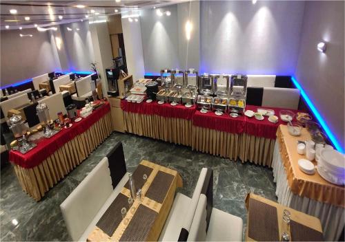 een panoramisch uitzicht op een feestzaal met tafels en stoelen bij Hotel Orange International in Surat