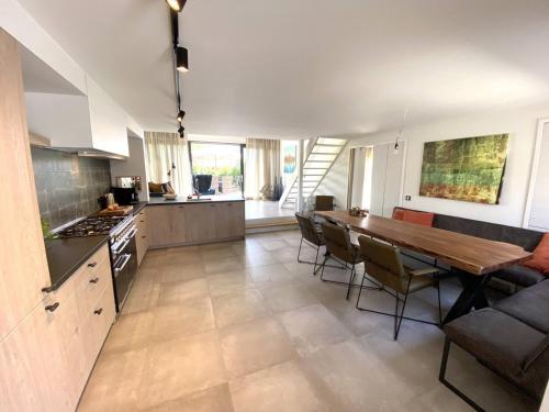 eine Küche und ein Esszimmer mit einem Tisch und Stühlen in der Unterkunft Holidayhouse - Lepelblad 44 Nieuwvliet-Bad in Nieuwvliet