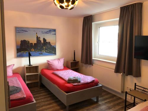 una camera da letto con due letti e una finestra di Ferienwohnung Herzberg a Gründau