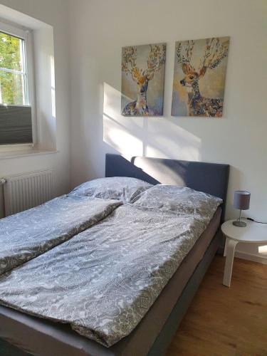 a bed in a bedroom with two paintings on the wall at Ferienwohnungen Unter den Eichen in Stade