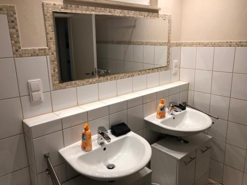 un bagno con due lavandini e uno specchio di Ferienwohnung Herzberg a Gründau