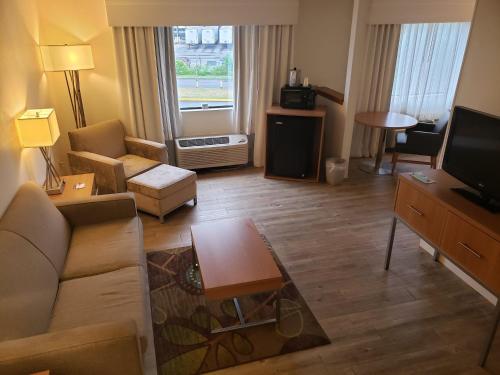 a living room with a couch and a television at Holiday Inn Express Hotel Pittsburgh-North/Harmarville by IHG in Harmarville