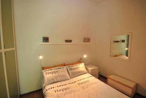 een kleine slaapkamer met een bed met vrolijke kussens bij Appartamento Nadia - Theater Home in Tignale