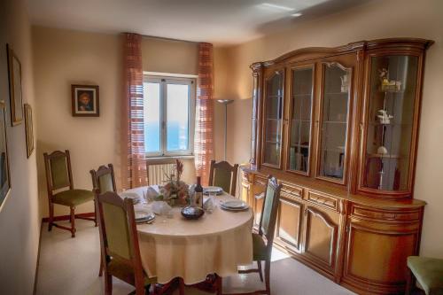 a dining room with a table and a china cabinet at Rustico Piletta, I Fiori - Rebomaholidays in Tignale