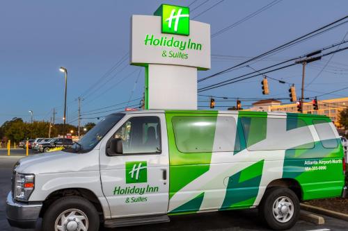 a white and green van parked in a parking lot at Holiday Inn & Suites Atlanta Airport North, an IHG Hotel in Atlanta