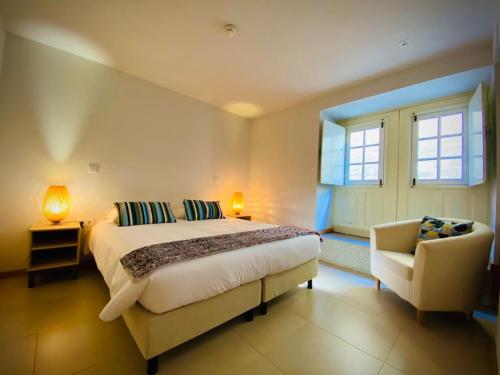 1 dormitorio con 1 cama, 1 silla y 1 ventana en Aldeia do Tâmega, en Amarante