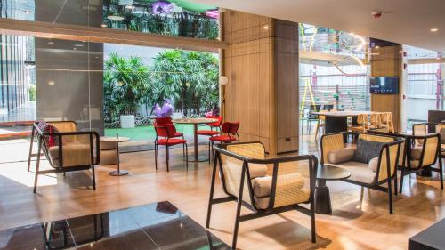 a lobby with chairs and tables in a building at Oakwood Residence Sukhumvit Thonglor Bangkok in Bangkok