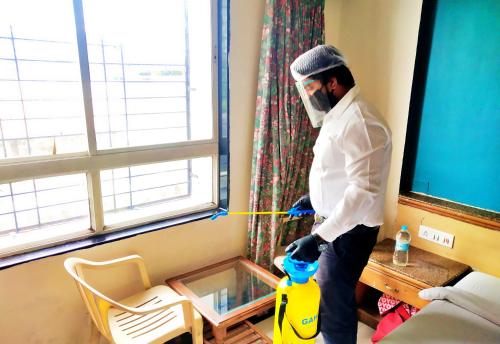 a man wearing a mask standing in a room at Celebrations Inn Pune in Pune