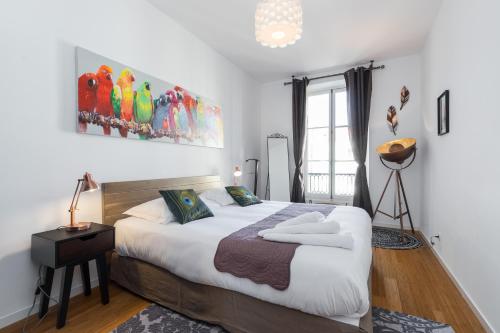 une chambre avec un grand lit blanc et une fenêtre dans l'établissement GIOFFREDO 14 - Spacious apartment with balcony, à Nice