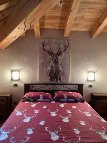 ein Schlafzimmer mit einem Bett mit einem Hirschgemälde an der Wand in der Unterkunft La Maison De Deni in Aymavilles