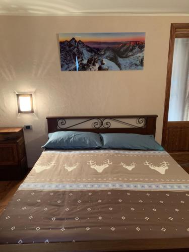 a bed with a wooden headboard with horses on it at La Maison De Deni in Aymavilles