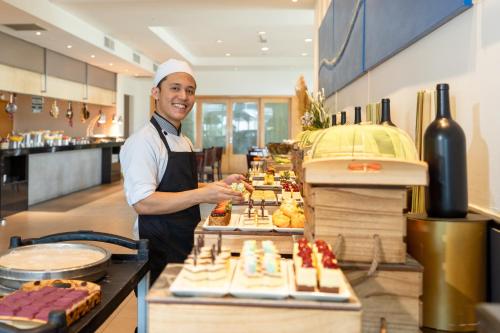 a chef standing behind a buffet of food at Holiday Inn Melaka by IHG in Melaka