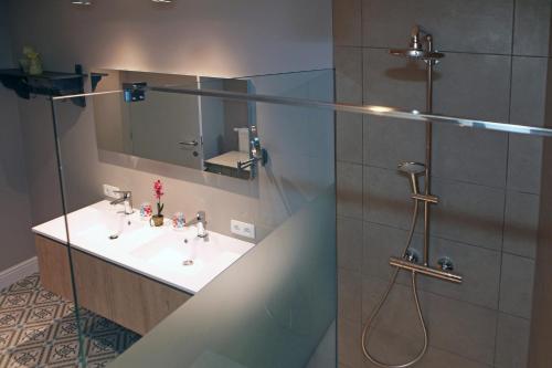 a bathroom with a sink and a shower at oyenkerke-loft in De Panne