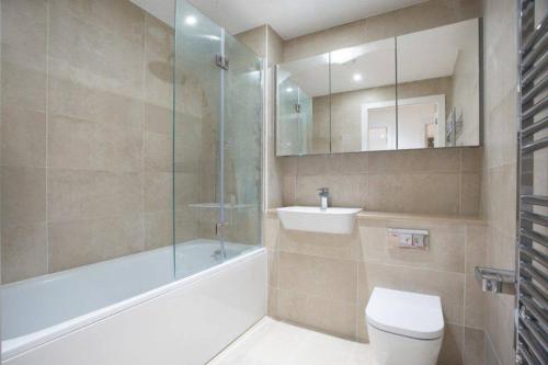 a bathroom with a toilet and a sink and a shower at LUXURY SERVICED APARTMENTS***** in Croydon