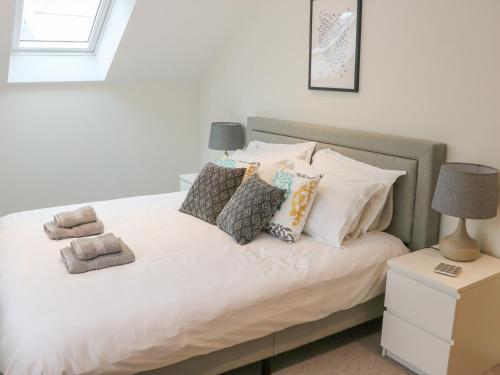 a bedroom with a bed with white sheets and pillows at Fig Cottage in Kirkby Stephen