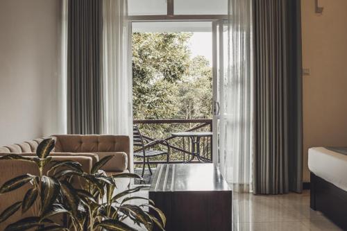- un salon avec un canapé et une table en verre dans l'établissement Tree of Life Nature Resort, à Kandy