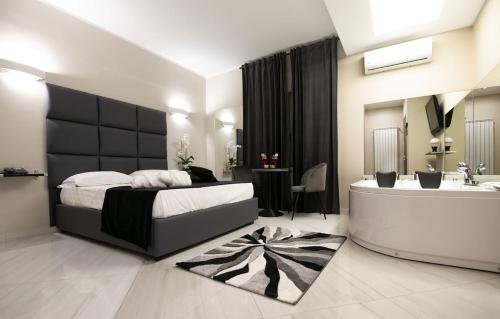 een slaapkamer met een bed, een bad en een wastafel bij Hotel Trionfal in Qualiano