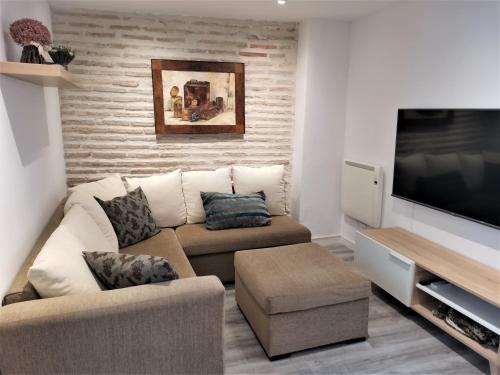 een woonkamer met een bank en een flatscreen-tv bij Casa Manuela Más que una Casa un Hogar in Toledo