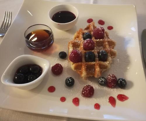een witte plaat met een wafel met bessen en stroop bij Ca' delle Rose in Castelfranco Veneto