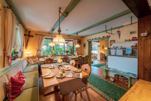 a living room with a table and a dining room at Hotel Garni Landhaus Traunbachhäusl in Ruhpolding