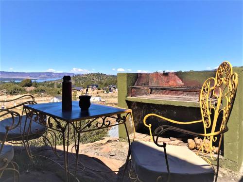 a table and chairs with a bottle on top of a piano at Hostel Andino in Villa Pehuenia