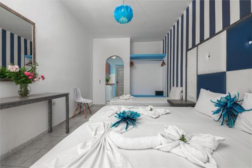 a large white bed with blue flowers on it at Boulevard Studio's with side seaview in Laganas