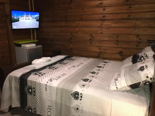 a bed in a room with a tv on a wall at Chambre1 Résidence Beauregard in Koungou