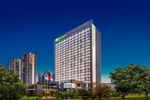 un edificio alto frente a una ciudad en Holiday Inn Putian Xiuyu by IHG, en Putian