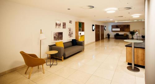 a living room with a couch and a table at Holiday Inn Łódź by IHG in Łódź