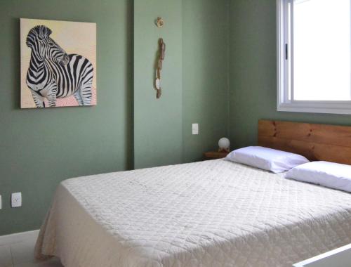 um quarto com uma cama com uma foto de uma zebra em Repouso Gaivotas em Florianópolis