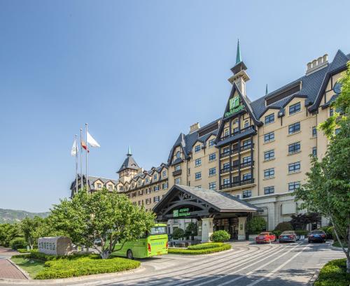 a large building with a bus parked in front of it at Hai Tian Expo Hotel in Qingdao