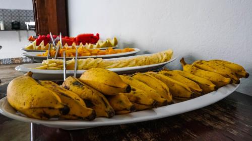 a bunch of bananas on plates on a table at Pousada o Amanhecer in Tiradentes