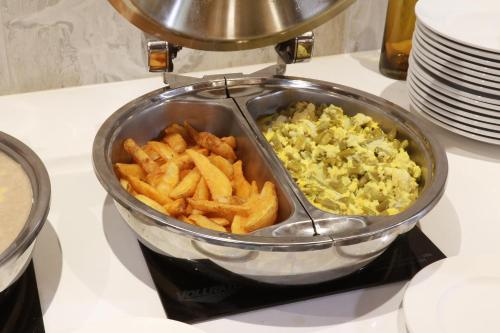 a food processor with french fries and eggs on a counter at Holiday Inn - Ciudad Juarez by IHG in Ciudad Juárez
