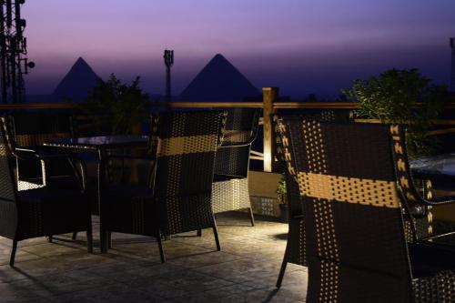 einen Tisch und Stühle auf einer Terrasse in der Nacht in der Unterkunft Rihana pyramids view in Kairo