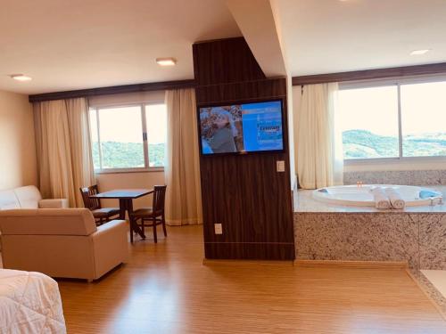 Camera d'albergo con vasca da bagno e TV di Hotel Mirante São Brás a São Brás do Suaçuí