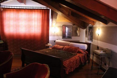 1 dormitorio con cama y cortina roja en Castello San Giuseppe - Historical bed and breakfast, en Chiaverano